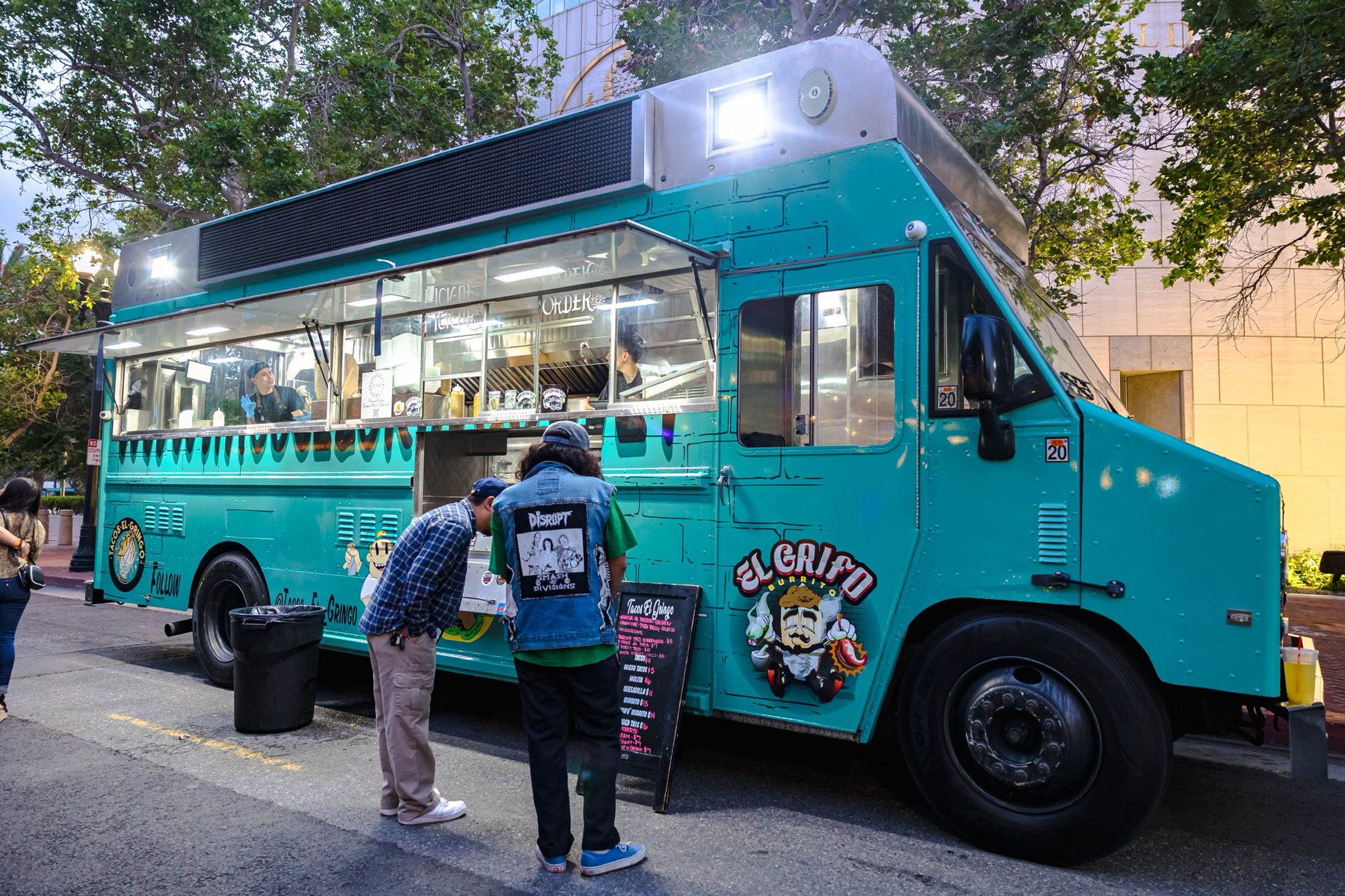 Clientes ordenando en la ventana del truck de Tacos El Gringo